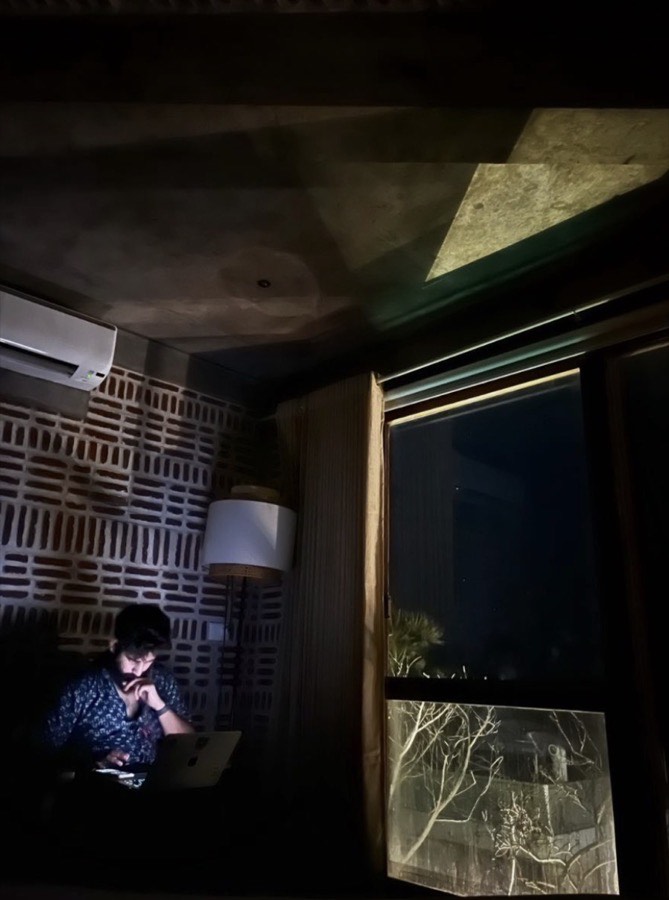 Working late at a laptop in a dim room, lit only by the screen.